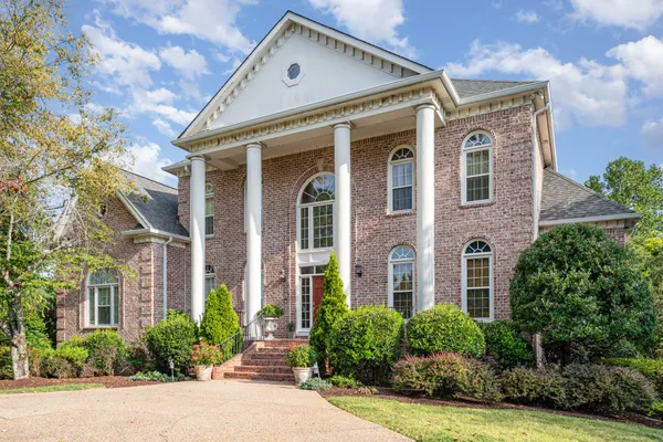 front view of a brick house with a yard
