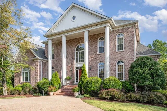 front view of a brick house with a yard
