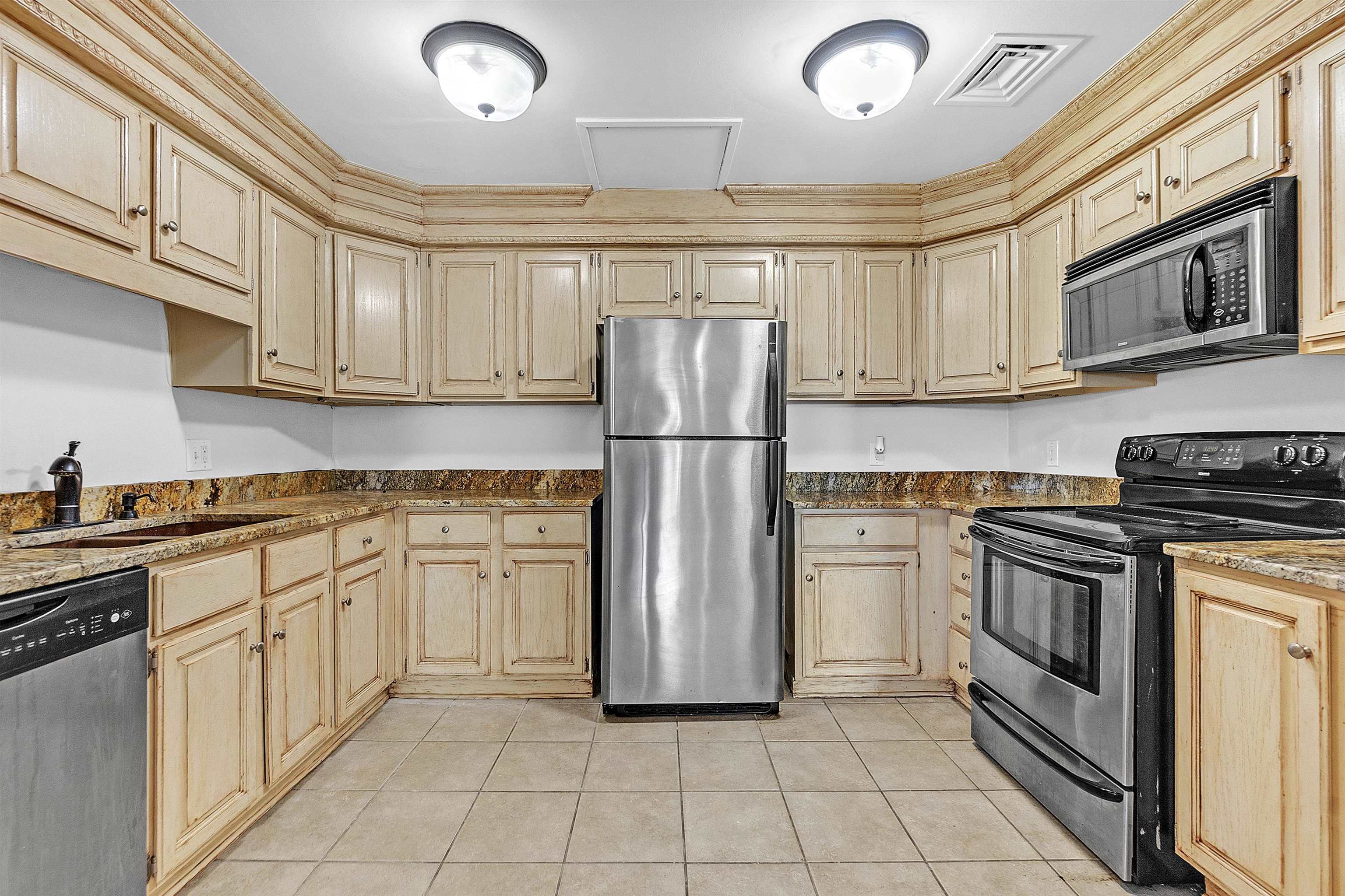655 Riverside Drive, Unit 206 Memphis, TN 38103 - Photo 15 of 28 a kitchen with stainless steel appliances granite countertop a refrigerator sink and stove