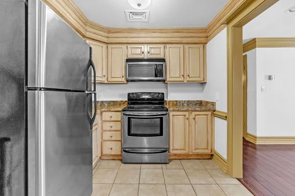 a kitchen with a refrigerator and a stove top oven