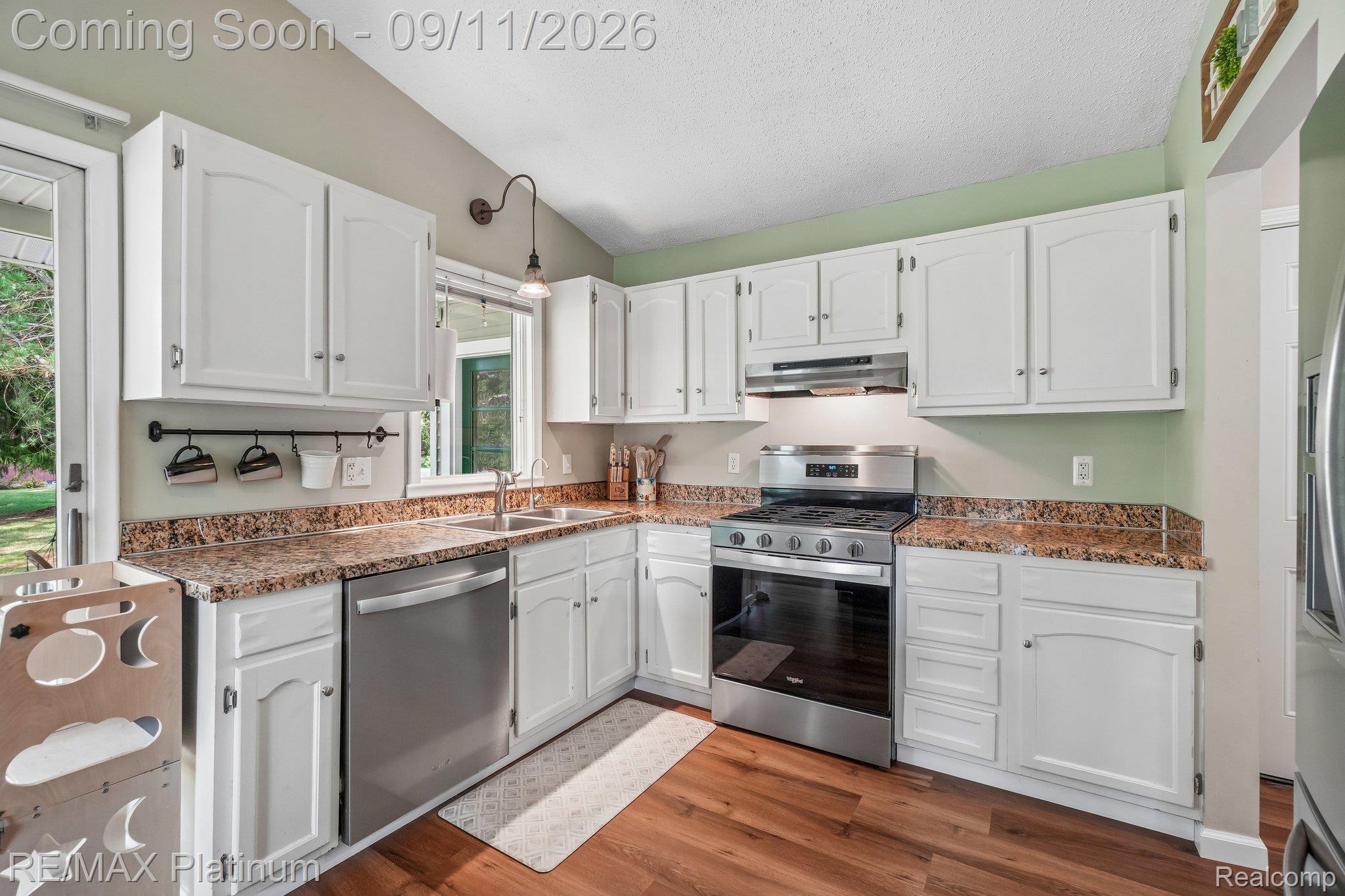12126 Linden Road Linden, MI 48451 - Photo 10 of 38 White cabinetry with stainless steel appliances, granite-look countertops, and LVP flooring