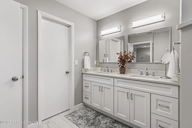 a bathroom with a double vanity sink and a mirror