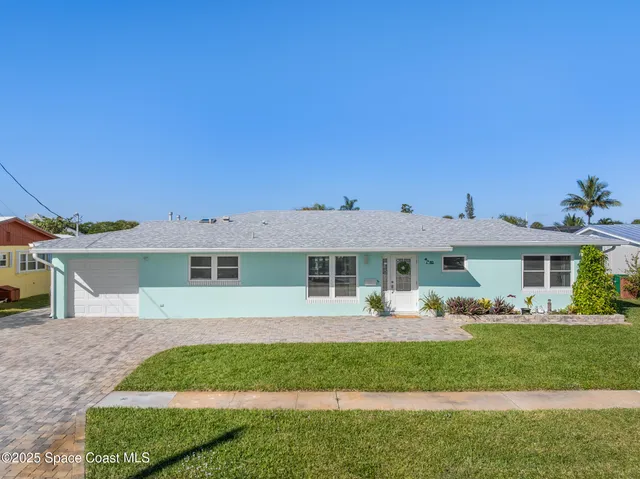 a front view of a house with a garden and plants