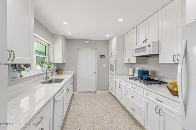 a kitchen with granite countertop a sink and cabinets