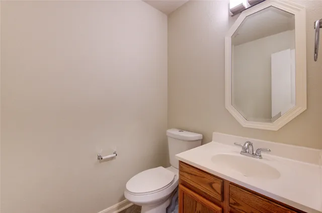 a bathroom with a toilet a sink and mirror