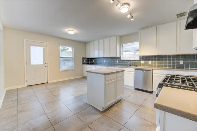 a kitchen with stainless steel appliances granite countertop a stove top oven a sink a counter top space and cabinets