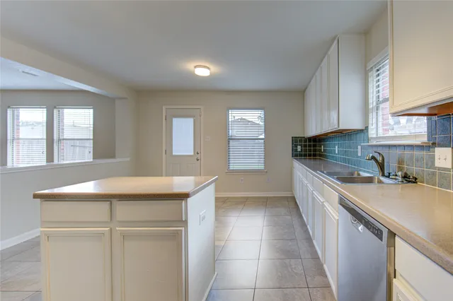 a kitchen with granite countertop a stove sink and cabinets