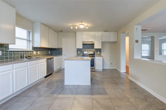 a kitchen with cabinets and window