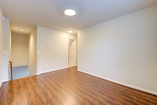 a view of an empty room with wooden floor