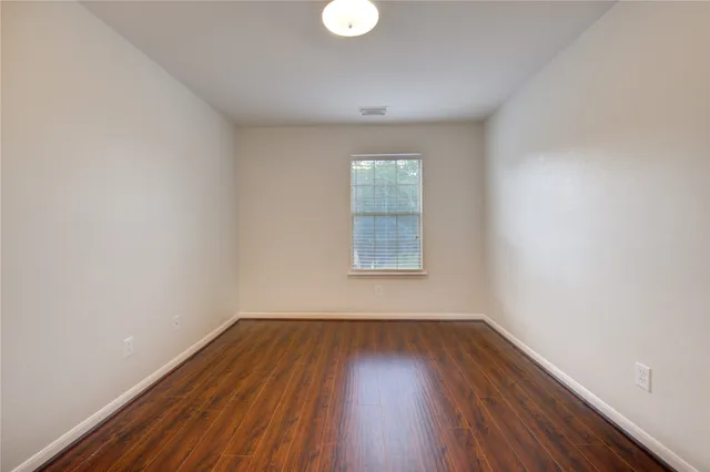 a view of a room with wooden floor and windows