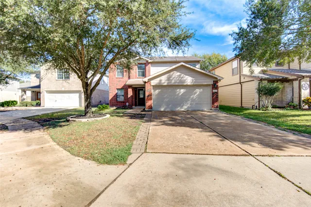 a view of a white house with a large tree
