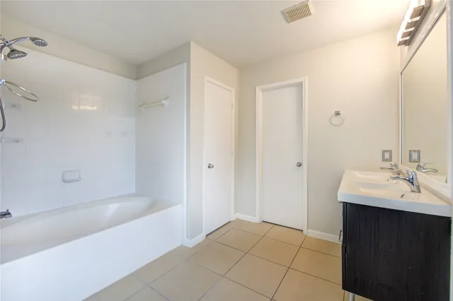 a bathroom with a bathtub sink vanity and mirror