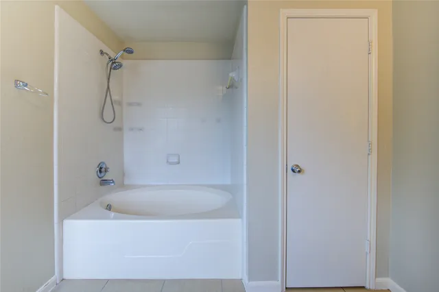 a white bath tub sitting next to a shower