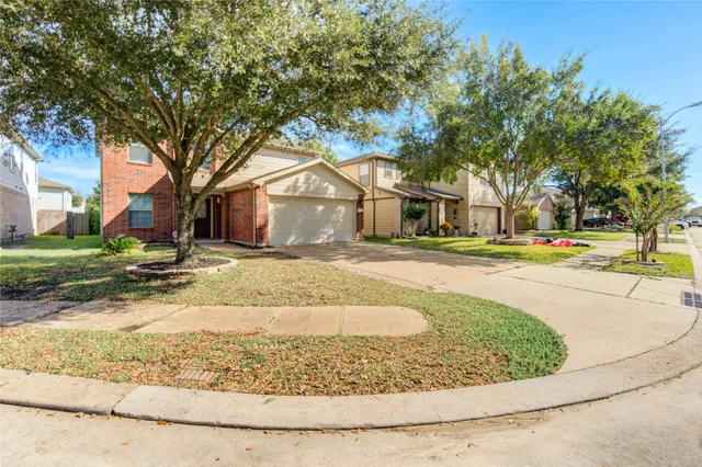 a view of a white house with a large tree