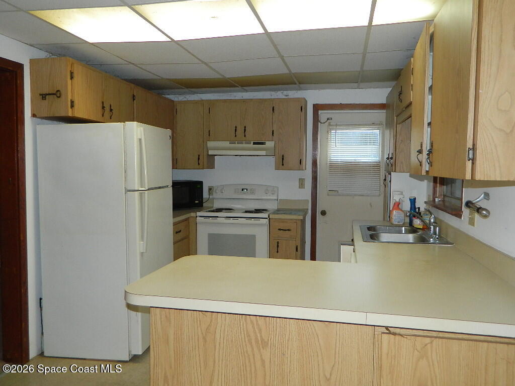 3755 Main Street Sebastian, FL 32976 - Photo 3 of 12 a kitchen with a refrigerator a stove and a sink with wooden floor