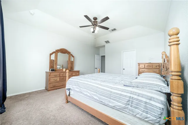 a bedroom with a bed and a ceiling fan