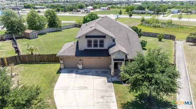an aerial view of a house with a yard and lake view