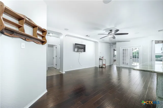 a kitchen with granite countertop wooden cabinets stainless steel appliances and a wooden floor