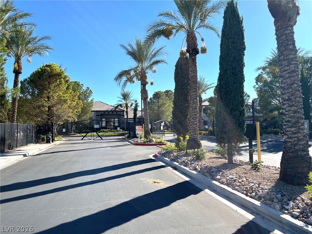 7255 West Sunset Road, Unit 2141 Las Vegas, NV 89113 - Photo 12 of 15 Towering palm trees frame the gated entrance under a clear blue sky.