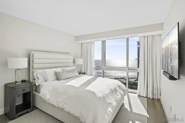 a bedroom with a bed and a large window