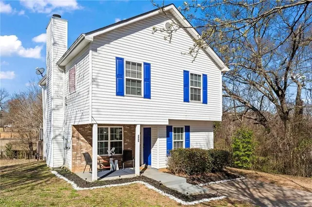 a view of a house with a yard and large tree