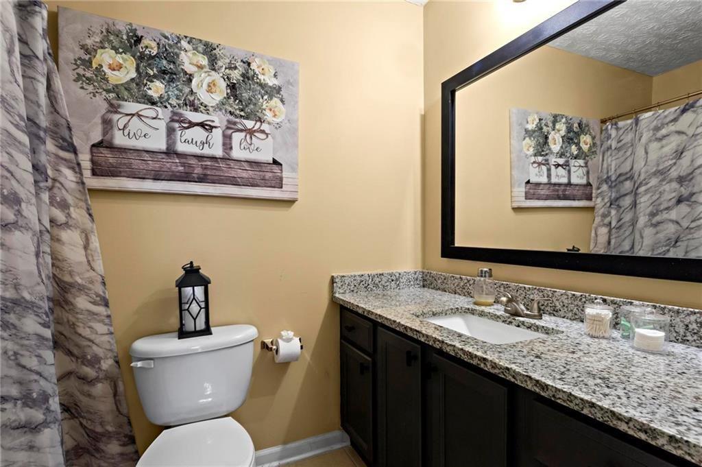 392 4th Street Forest Park, GA 30297 - Photo 18 of 21 a bathroom with a granite countertop toilet sink and mirror