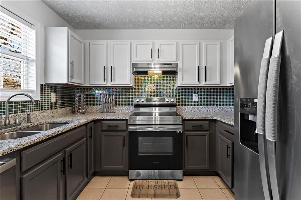 392 4th Street Forest Park, GA 30297 - Photo 9 of 21 a kitchen with kitchen island granite countertop a stove sink and refrigerator