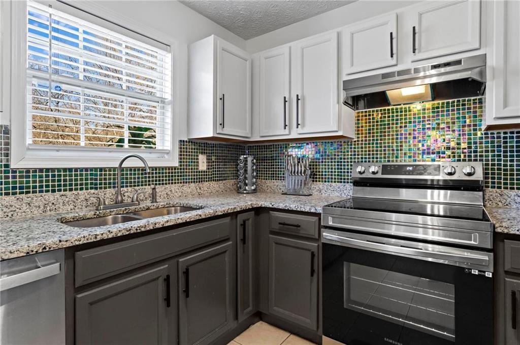 392 4th Street Forest Park, GA 30297 - Photo 10 of 21 a kitchen with granite countertop a sink stove and cabinets