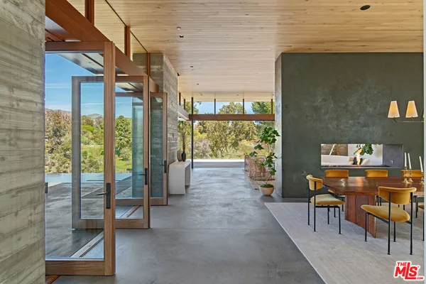 a view of a porch with chairs and floor to ceiling window