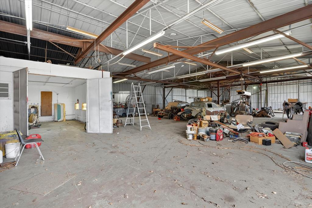 1092 West Highway 199 Springtown, TX 76082 - Photo 22 of 29 Garage space featuring a concrete floor, paint booth exposed metal beam structure, and high ceilings
