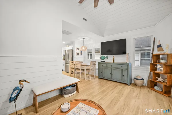 a room with furniture a flat screen tv and kitchen view