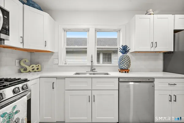 a kitchen with white cabinets and stainless steel appliances