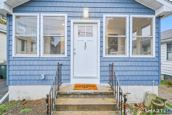 a wooden bench sitting in front of a house