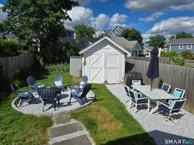 a view of a patio with table and chairs with wooden fence and plants