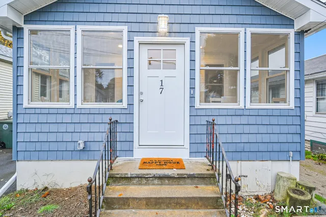 a wooden bench sitting in front of a house