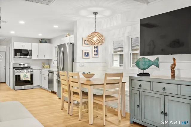 a kitchen with stainless steel appliances kitchen island granite countertop a table and chairs in it