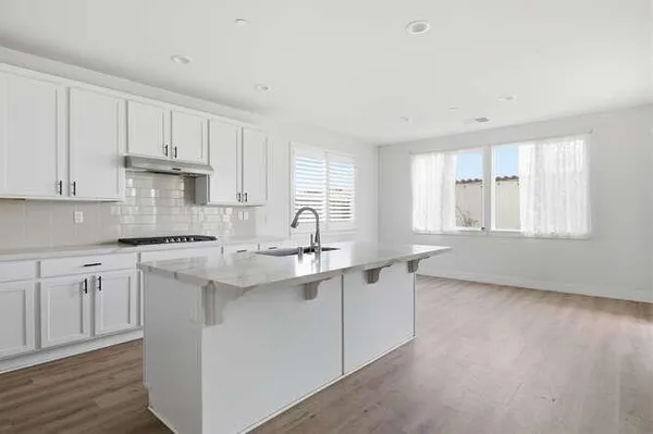 a kitchen with stainless steel appliances granite countertop a sink stove and cabinets