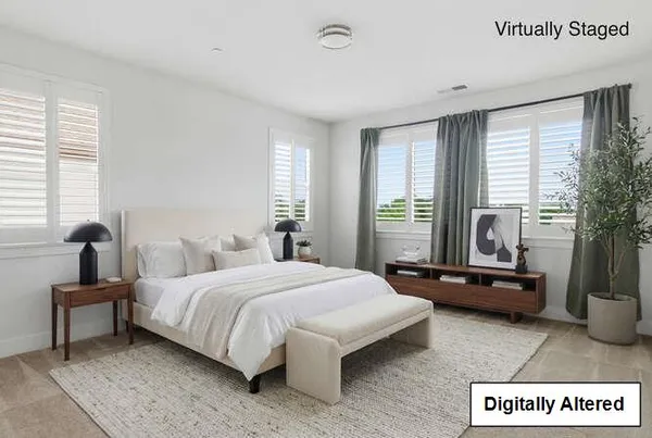 a bedroom with a bed and large windows