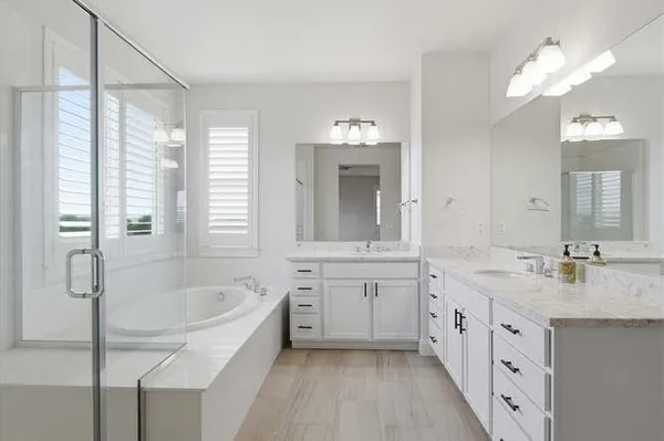 a spacious bathroom with a granite countertop tub sink shower and mirror