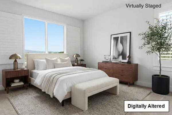 a spacious bedroom with a bed a couch and a potted plant