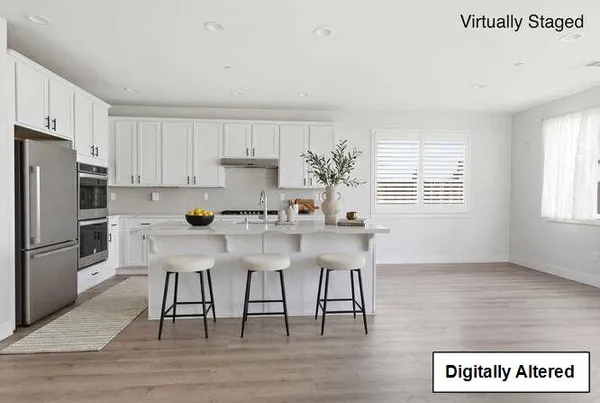 a kitchen with stainless steel appliances granite countertop a white cabinets and wooden floor
