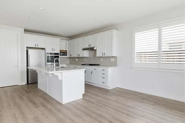 a kitchen with white cabinets and white appliances