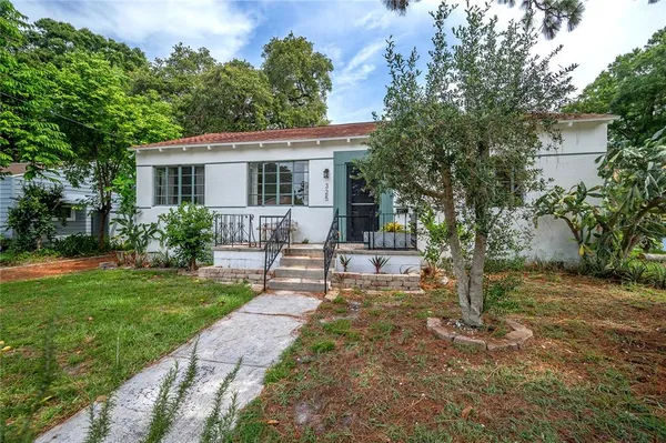 a view of a house with backyard and sitting area
