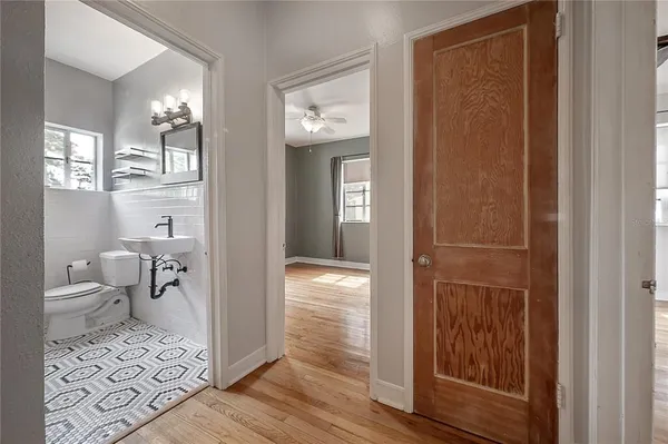 a view of a hallway with wooden floor and a livingroom