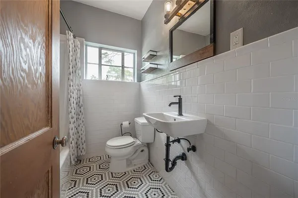 a bathroom with a sink a toilet and a window
