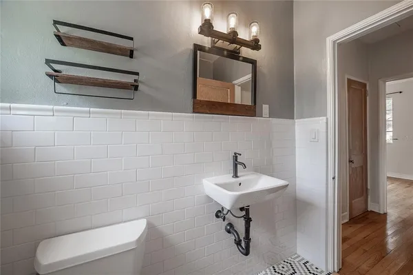 a bathroom with a toilet a sink and mirror