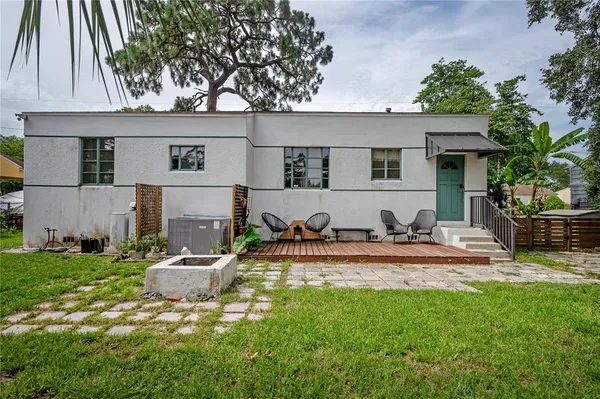 a view of a house with backyard and sitting area