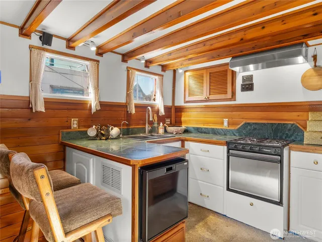 a kitchen with a sink and a stove next to a window