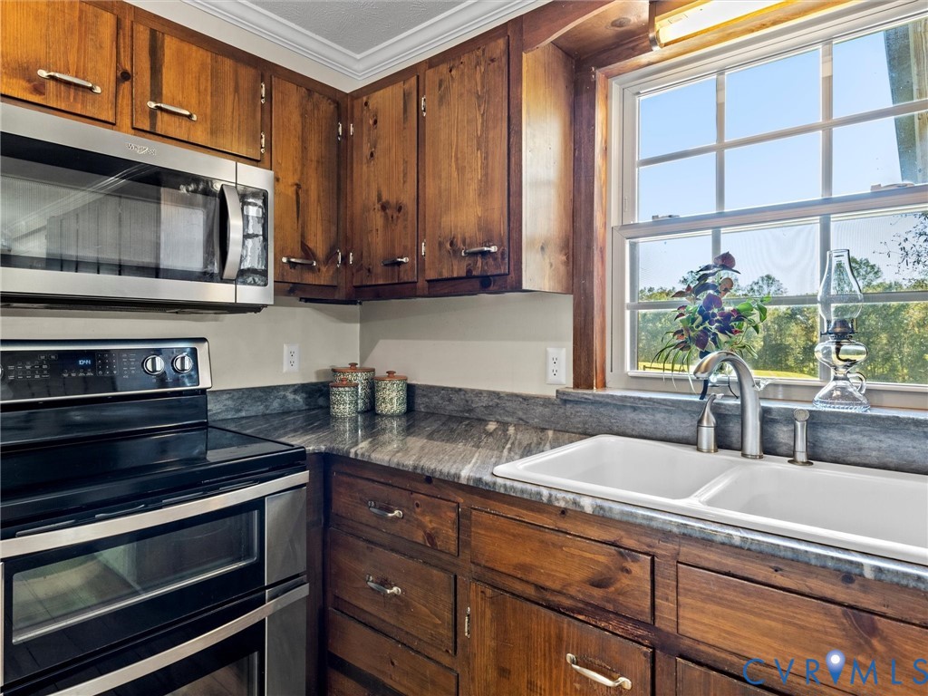 1024 Back Mountain Road Dillwyn, VA 23936 - Photo 16 of 50 a kitchen with stainless steel appliances granite countertop a stove a microwave and cabinets