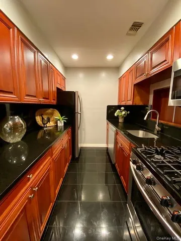 a kitchen with granite countertop stove and cabinets